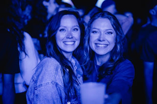 Zwei Frauen auf dem In litore Festival grinsend vor der Kamera bei nacht.